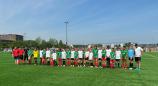 Eine große Gruppe von jungen Fußballspielern posiert in einer Reihe auf einem grünen Spielfeld.