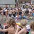 Eine große Menschenmenge versammelt sich draußen bei einem sommerlichen Fest oder Event.