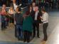 Eine Gruppe von Menschen steht in einer Halle und nimmt an einem Treffen teil.