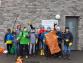 Eine Gruppe von Kindern in Kostümen mit Schwertrequisiten posiert vor einer Ziegelsteinwand.