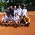 Gruppe von Männern und einer Frau, die auf einem Tennisplatz posieren.