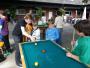 Eine Gruppe von Jungen spielt draußen an einem Pooltisch.