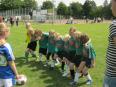 Eine Gruppe junger Jungen spielt Fußball auf einem großen Rasenfeld.