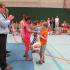 Eine Gruppe von Kindern und Erwachsenen betreibt sportliche Aktivität in einer Turnhalle.
