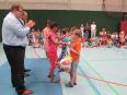 Eine Gruppe von Kindern und Erwachsenen betreibt sportliche Aktivität in einer Turnhalle.