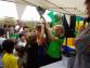 Eine Gruppe von Menschen bei einem Fest oder Jahrmarkt unter einem weißen Zelt.