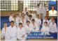 Gruppenbild eines Judo-Kursets, das Kinder und Erwachsene in Sportkleidung zeigt.