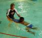 Ein Erwachsener unterstützt ein Kind beim Schwimmen in einem Schwimmbecken.