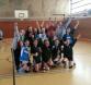 Große Gruppe von Menschen, die in einer Sporthalle für ein Gruppenfoto posieren.