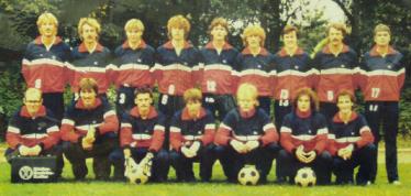 Eine große Gruppe von Männern in Sportkleidung für ein Gruppenfoto im Freien.