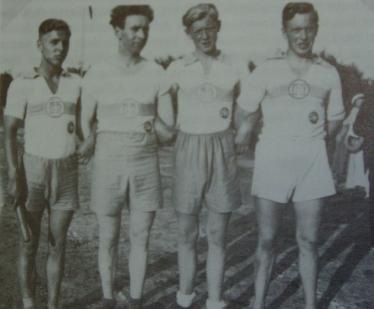 Drei Männer in sportlichen Uniformen posieren vor einem unscharfen Hintergrund.