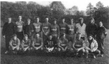 Eine historische Schwarz-Weiß-Fotografie einer Gruppe von Männern, wahrscheinlich einem Sportteam, die draußen posieren.