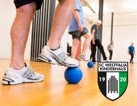 Mehrere Personen beim Training in einer Turnhalle, die Sportkleidung tragen und auf einem Ball stehen.