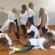 Gruppe von Frauen, die gemeinsam Yoga- oder Dehnübungen in einem Studio durchführen.