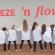Eine Gruppe von Menschen, die in einer Reihe posieren und verschiedene Posen einnehmen, vor einem Hintergrund mit dem Schriftzug Freeze n flow.
